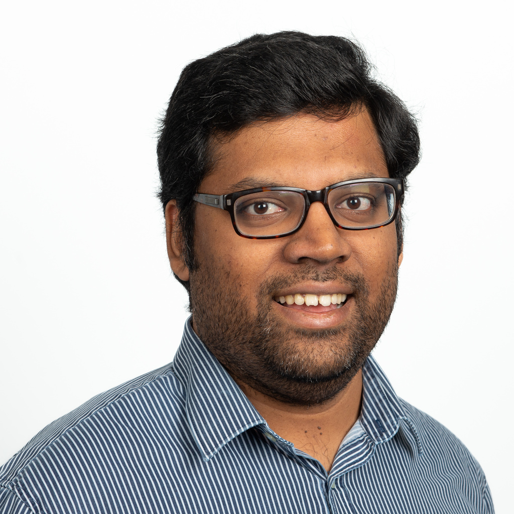 man with blue shirt and glasses